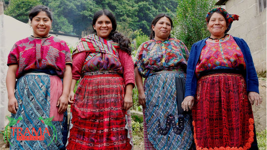 Group of smiling Mayan weavers, dressed in red and blue traditional huipil and corte, from an Indigenous Community of the Guatemalan Highlands