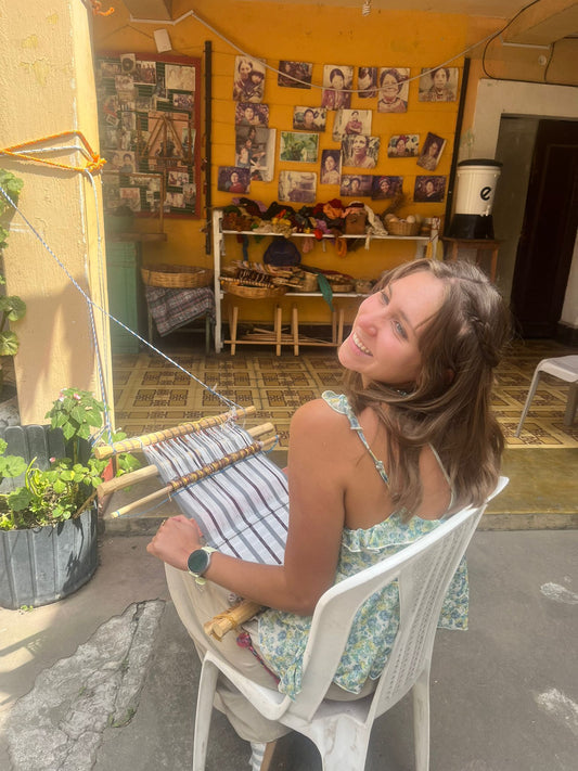 Emily, a Trama Textile's volunteer from the United States, weaving a scarf using the traditional Maya backstrap loom.